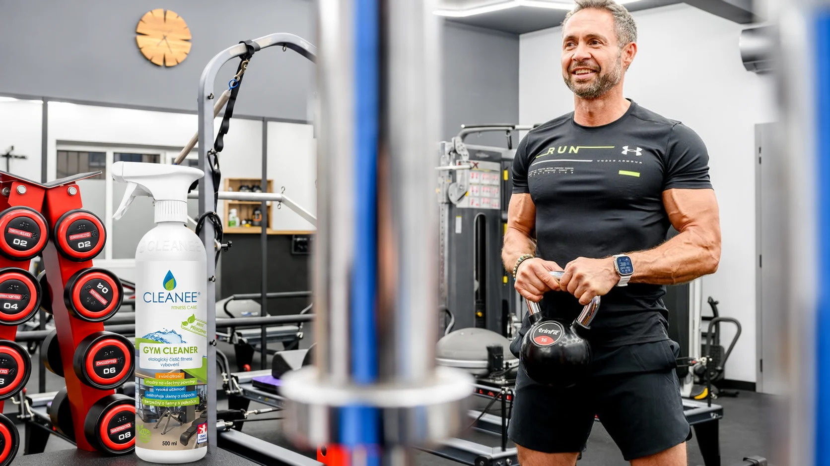 Štefan Bitto s kettlebellem a CLEANEE Gym Cleaner ve studiu