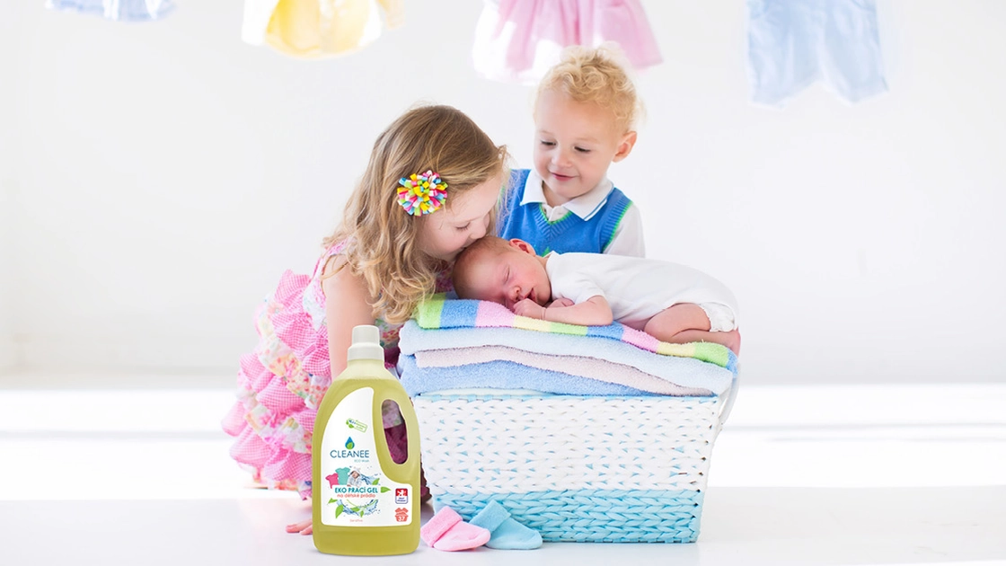 Děti u koše s čerstvě vypranými ručníky a lahev pracího gelu CLEANEE na dětské prádlo 1,5 l